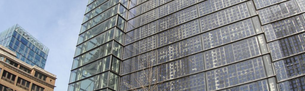 architectural glass manufacturer showcasing a full building facade with sunlight reflecting off it