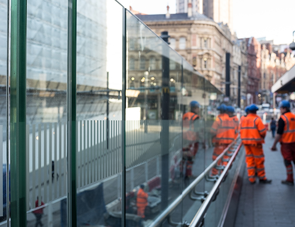 Glass wall around Birmingham New Street with engineers to illustrate the lamitecsuper product from toughened glass manufacturers Kite Glass Weybridge