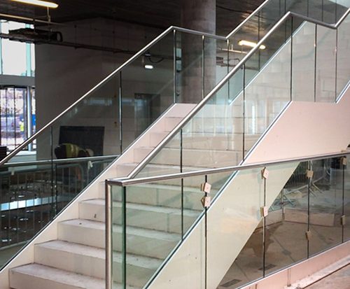 Photo of staircase with beautiful glass bannisters to illustrate the work of toughened glass manufacturers Kite Glass Weybridge