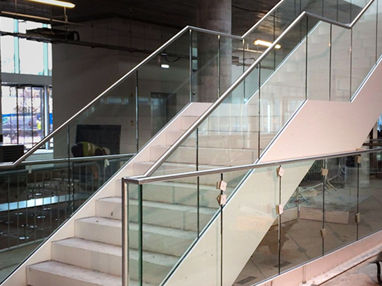 Photo of staircase with beautiful glass bannisters to illustrate the work of toughened glass manufacturers Kite Glass Weybridge