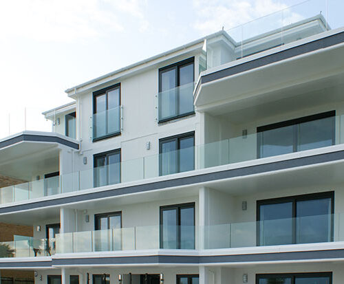 Sunny picture of apartments in Sandbanks, Poole showing work by toughened glass suppliers Kite Glass Weybridge on the balconies