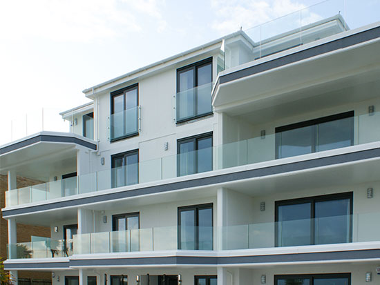 Sunny picture of apartments in Sandbanks, Poole showing work by toughened glass suppliers Kite Glass Weybridge on the balconies
