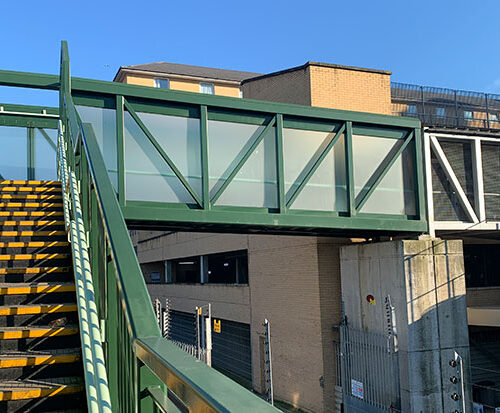 Feltham Station with security glass forming the walls of the passenger footbridge