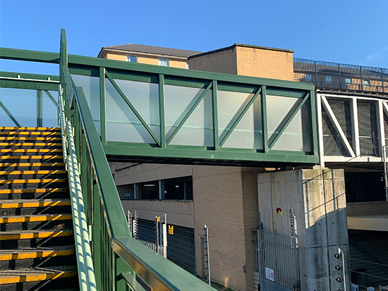 Feltham Station with security glass forming the walls of the passenger footbridge